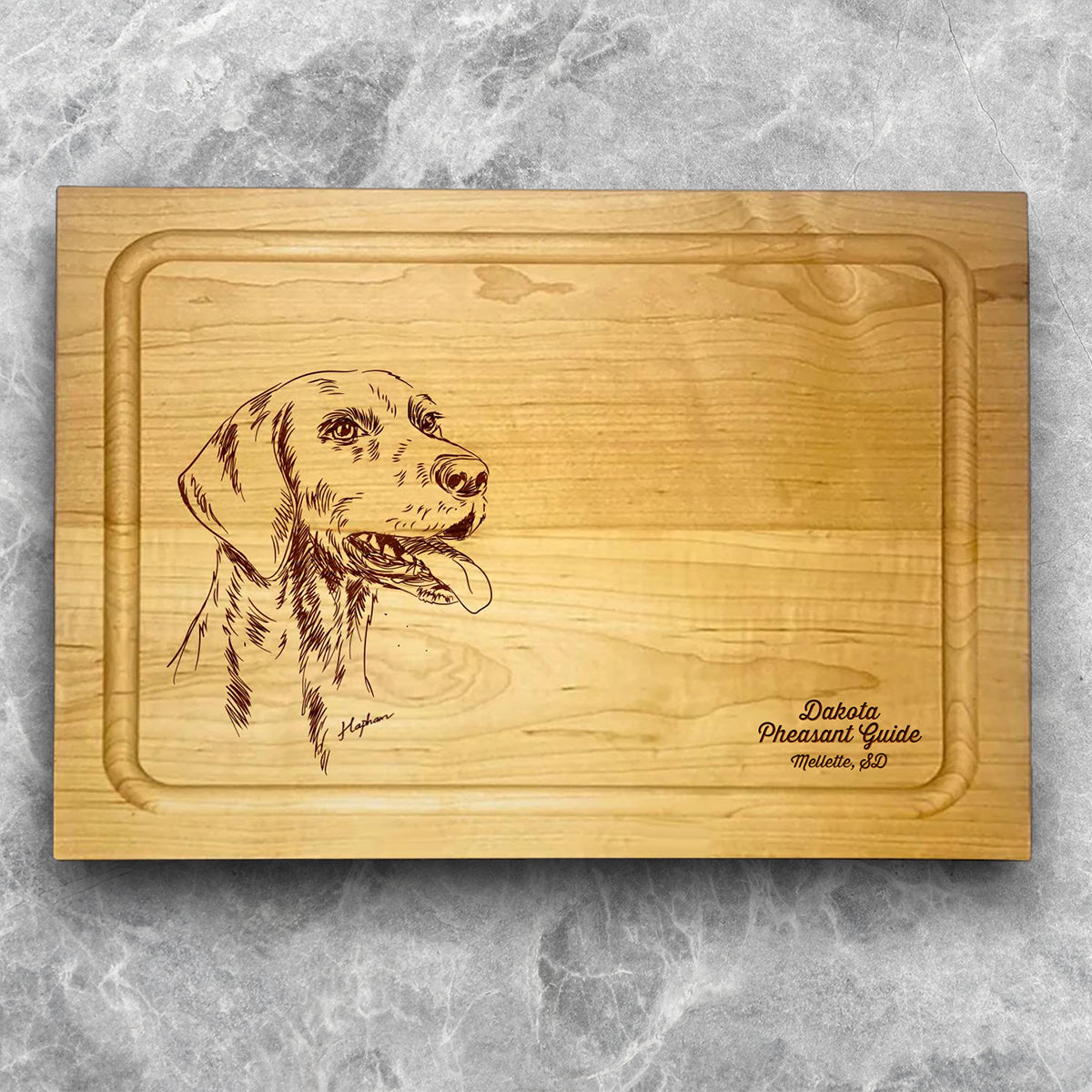 A high-quality, durable maple cutting board with juice groove featuring a laser-engraved German Shorthair Pointer. A perfect addition for any kitchen, and a wonderful reminder of your love of hunting and sporting dogs. A Dakota Pheasant Guide souvenir.