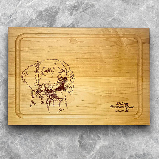 A high-quality, durable maple cutting board with juice groove featuring a laser-engraved Golden Retriever. A perfect addition for any kitchen, and a wonderful reminder of your love of hunting and sporting dogs. A Dakota Pheasant Guide souvenir.