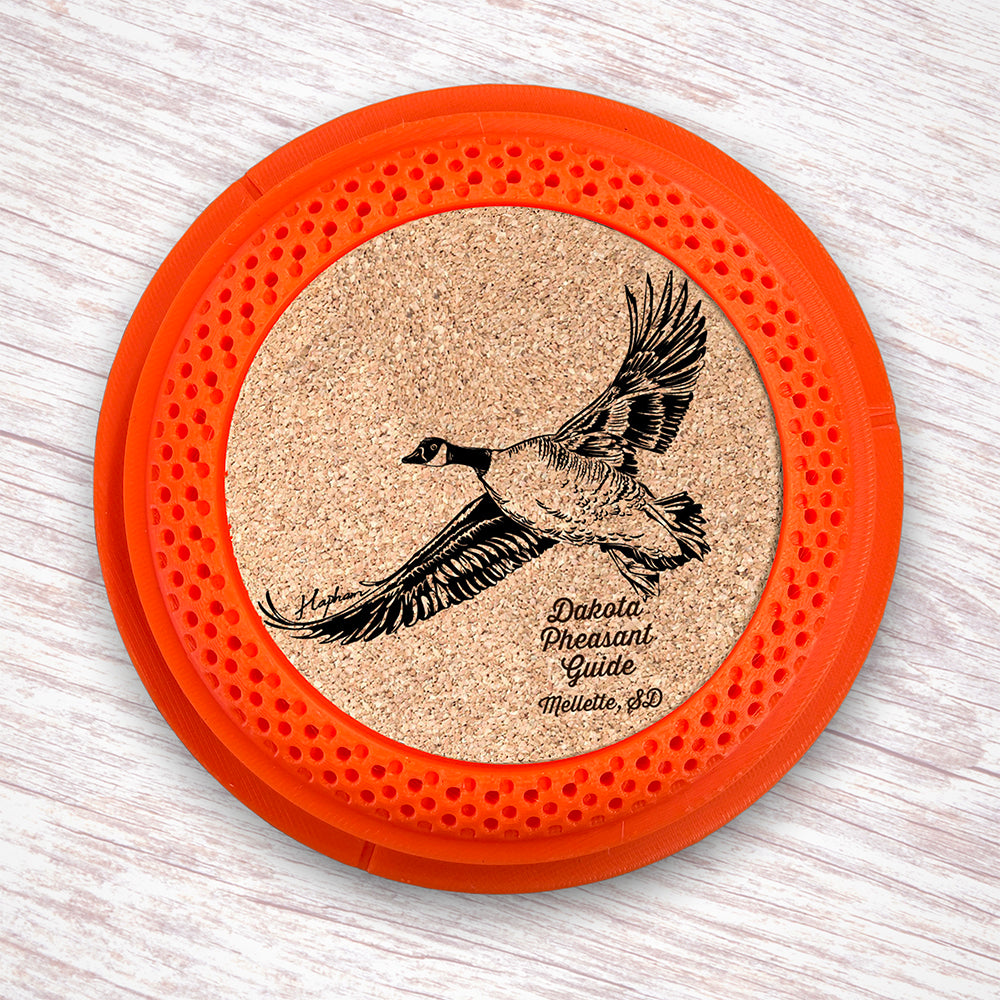 Clay Pigeon shaped coaster base with laser-engraved cork inserts featuring a Canada Goose - this set of 4 coasters makes a unique gift for any trap shooter, gun enthusiast and game bird lover! By Muggins Gifts for the Dakota Pheasant Guide Souvenir shop.