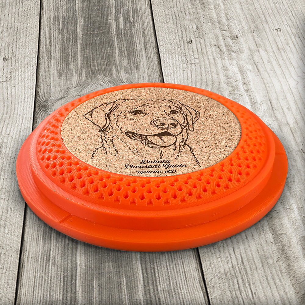 Clay Pigeon shaped coaster base with a laser-engraved cork insert featuring a Labrador Retriever - this set of 4 coasters makes a unique gift for any trap shooter, gun enthusiast and bird dog lover! By Muggins Gifts for the Dakota Pheasant Guide Souvenir shop.