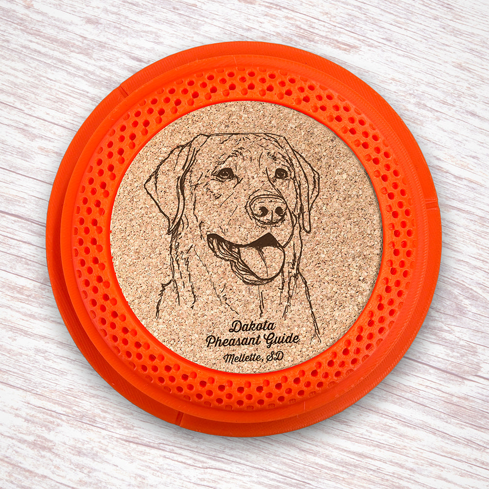 Clay Pigeon shaped coaster base with a laser-engraved cork insert featuring a Labrador Retriever - this set of 4 coasters makes a unique gift for any trap shooter, gun enthusiast and bird dog lover! By Muggins Gifts for the Dakota Pheasant Guide Souvenir shop.