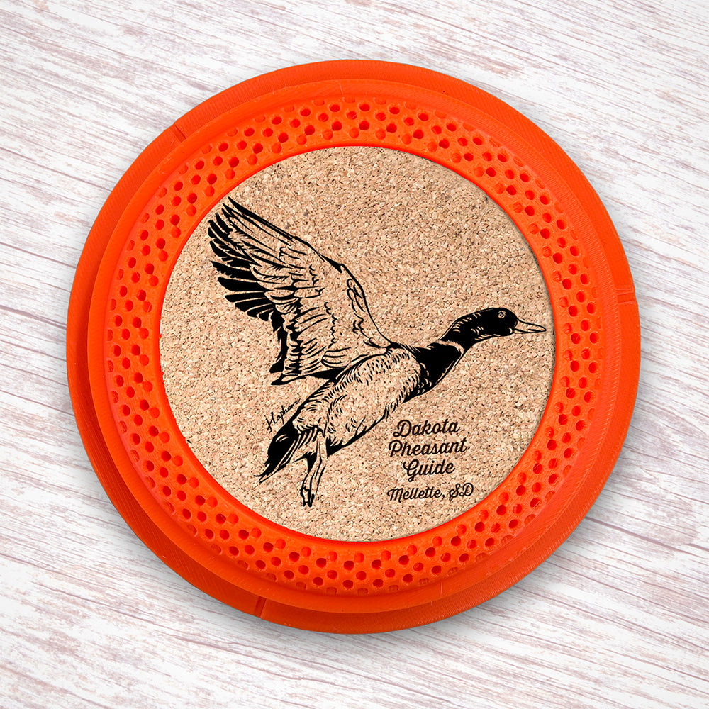 Clay Pigeon shaped coaster base with laser-engraved cork inserts featuring a Mallard Duck - this set of 4 coasters makes a unique gift for any trap shooter, gun enthusiast and game bird lover! By Muggins Gifts for the Dakota Pheasant Guide Souvenir shop.