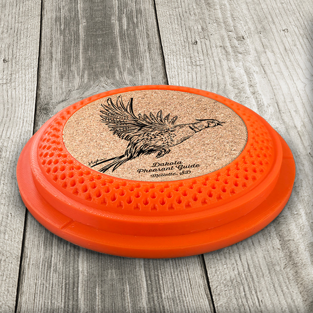 Clay Pigeon shaped coaster base with a laser-engraved cork insert featuring a Pheasant taking flight - this set of 4 coasters makes a unique gift for any trap shooter, gun enthusiast and bird dog lover! By Muggins Gifts for the Dakota Pheasant Guide Souvenir shop.