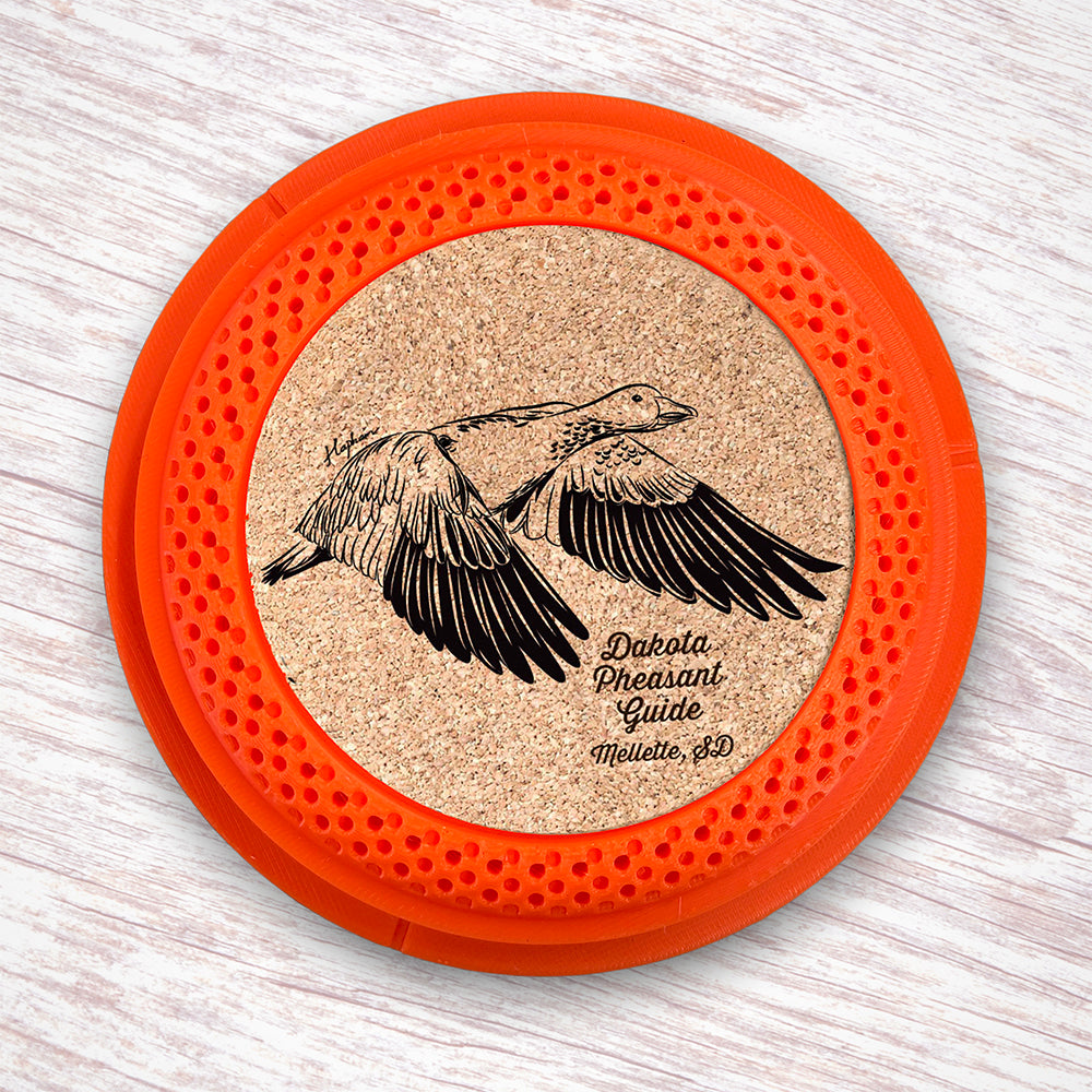 Clay Pigeon shaped coaster base with laser-engraved cork inserts featuring a Snow Goose - this set of 4 coasters makes a unique gift for any trap shooter, gun enthusiast and game bird lover! By Muggins Gifts for the Dakota Pheasant Guide Souvenir shop.