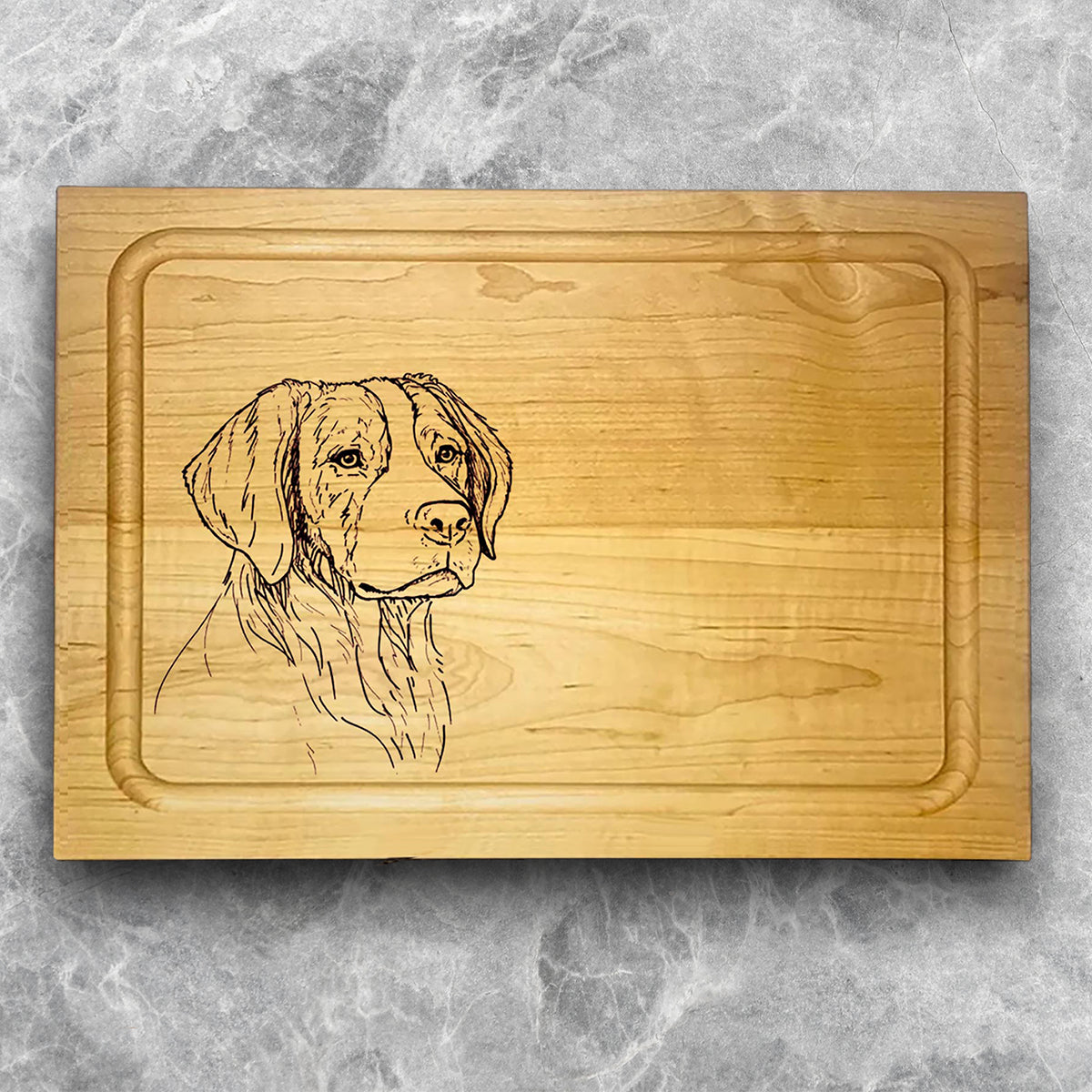 A high-quality, durable maple cutting board with juice groove featuring a laser-engraved Brittany Spaniel. A perfect addition for any kitchen, and a wonderful reminder of your love of hunting and sporting dogs. A Dakota Pheasant Guide souvenir.