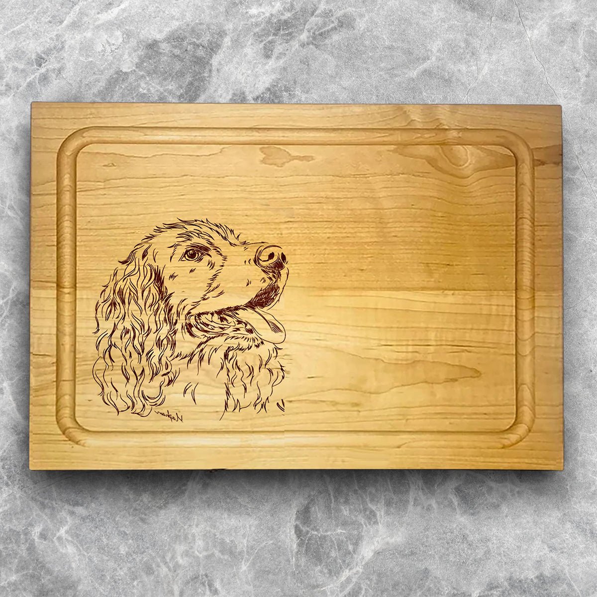 A high-quality, durable maple cutting board with juice groove featuring a laser-engraved Springer Spaniel. A perfect addition for any kitchen, and a wonderful reminder of your love of hunting and sporting dogs.